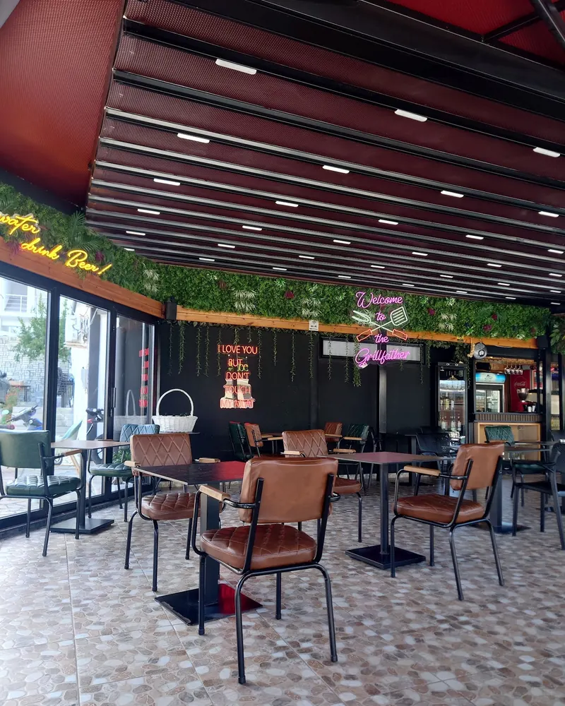 The covered dining room with leather chairs, plants and neon signs