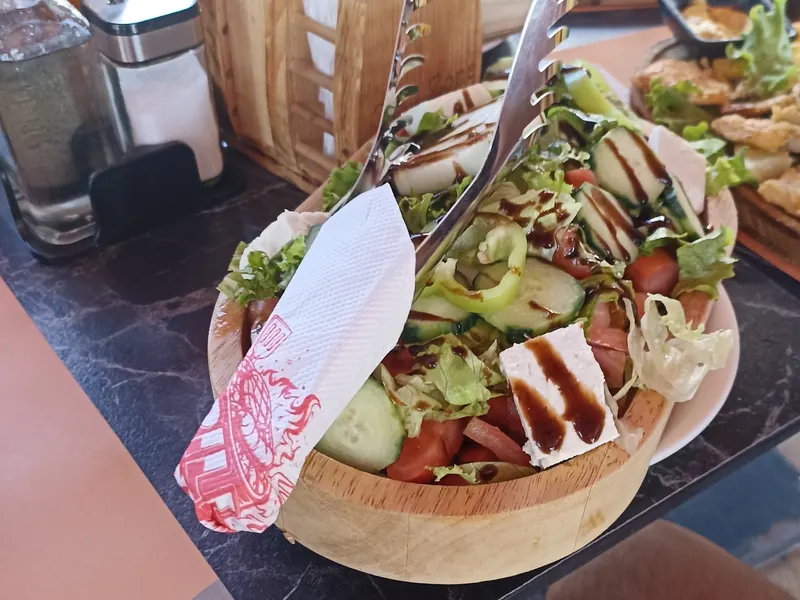 Village salad with feta, tomato and cucumber in a wooden bowl
