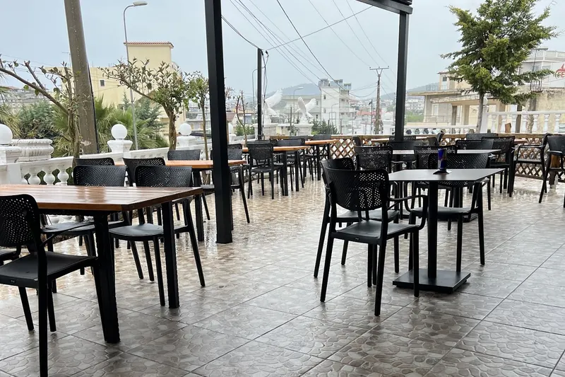 The open terrace with black tables and chairs on a bright day